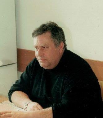 Fotografia przedstawiająca Patrona Fundacji Pomocy Chorym Psychicznie - Tomasza Deca. Zdjęcie uwiecznia Pana Tomasza siedzącego przy biurku.